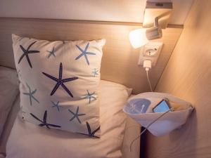 a bed with a pillow with blue stars on it at Strand 13 in Scharbeutz