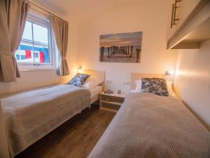 a bedroom with two beds and a window at Strand 13 in Scharbeutz