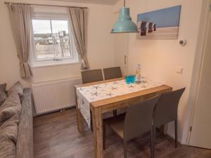 a dining room with a table and chairs at Strand 13 in Scharbeutz +7 photos
