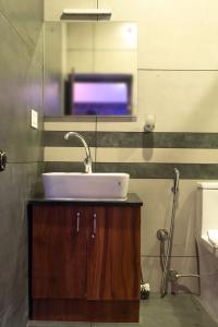 a bathroom with a sink and a tv on the wall at Pomma Holidays and Resorts in Muthanga +23 photos