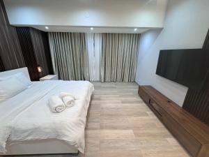 a hotel room with a bed and a flat screen tv at Propriedade Neto no centro da cidade de Luanda in Luanda