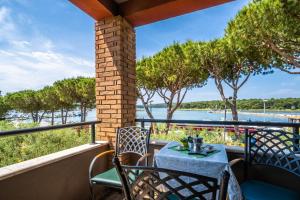 a table and chairs on a balcony with a view of the water at Apartments Oliveto - Calming Sea View in Medulin