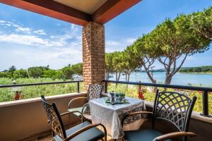 ein Tisch und Stühle auf einem Balkon mit Blick auf das Wasser in der Unterkunft Apartments Oliveto - Calming Sea View in Medulin