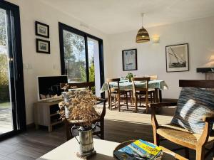 a living room with a table and a dining room at Ty Kerbihan, confortable maison au calme, 200m plage in La Trinité-sur-Mer