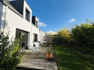 a wooden deck with a table and chairs on it at Ty Kerbihan, confortable maison au calme, 200m plage in La Trinité-sur-Mer
