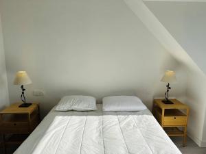 a bedroom with a white bed with two night stands at Ty Kerbihan, confortable maison au calme, 200m plage in La Trinité-sur-Mer