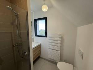 a bathroom with a shower and a toilet and a window at Ty Kerbihan, confortable maison au calme, 200m plage in La Trinité-sur-Mer +22 photos