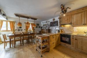 a kitchen with wooden cabinets and a table with chairs at Chesa Champagna - Madulain in Madulain