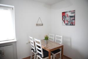 a dining room table and chairs with a vase of flowers on it at Bermuda Apartment in Bochum