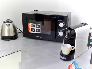 a microwave sitting on a counter next to a coffee maker at [RHO FIERA] Apartment near the Metro in Pero +10 photos