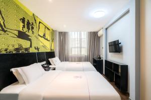 Letto o letti in una camera di Yihai Cultural Hotel Coffee, fruits, snacks, a gym and a laundry room are provided for free in the lobby