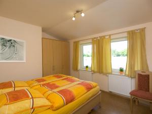 a bedroom with a bed and two windows at Bauernhof Sauer - Heuerhus in Varel