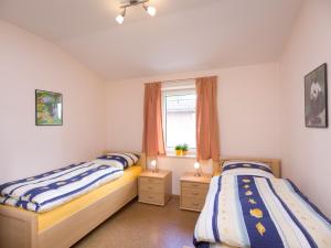 two twin beds in a bedroom with a window at Bauernhof Sauer - Heuerhus in Varel
