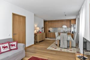a living room and kitchen with a table and a couch at Chesa Chalavus - St. Moritz in St. Moritz