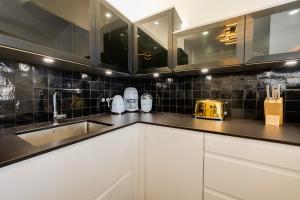a kitchen with white cabinets and a sink at Le Saphir - Vue panoramique sur le lac d'Annecy in Annecy +18 photos