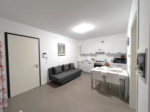 a kitchen and a living room with a couch and a table at Scala Santa Apartment in Trieste +14 photos