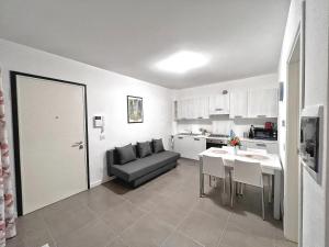 a kitchen and a living room with a couch and a table at Scala Santa Apartment in Trieste