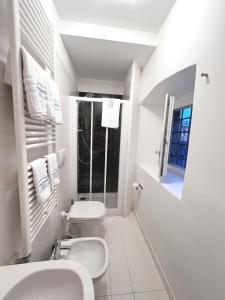a white bathroom with a toilet and a sink at Scala Santa Apartment in Trieste