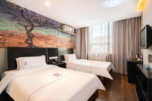 una camera d'albergo con due letti e un dipinto sul muro di Yihai Cultural Hotel Coffee, fruits, snacks, a gym and a laundry room are provided for free in the lobby a Pechino