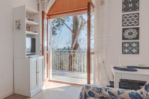 a living room with a sliding glass door leading to a balcony at ElTufeto Apartment - Parking and Terrace in Grado-Pineta