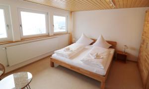 a bedroom with a bed with white sheets and pillows at Haus Findling, 10 Personen, Schluchsee, Hochschwarzwaldkarte in Schluchsee +16 photos