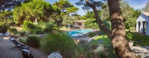 a backyard with a swimming pool and a house at Villa Petit Marchais in Les Portes