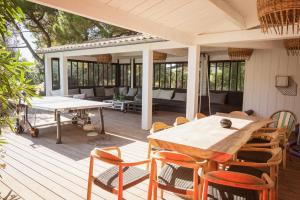 a patio with a table and chairs on a deck at Villa Petit Marchais in Les Portes