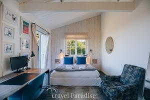 a bedroom with a bed and a desk and a chair at Villa Petit Marchais in Les Portes