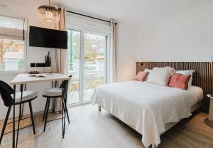 a bedroom with a bed and a desk and a table at Appart Hotel Neostelia in Annecy
