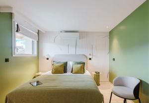 a bedroom with a large bed and a chair at Appart Hotel Neostelia in Annecy