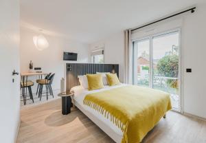 a bedroom with a large bed with a yellow blanket at Appart Hotel Neostelia in Annecy