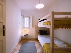 een slaapkamer met twee stapelbedden en een raam bij Casa Porta da Vila in Óbidos