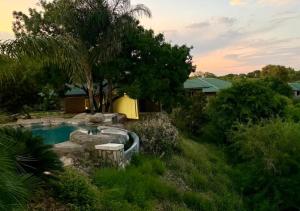a backyard with a swimming pool and trees and a house at Simanya River Lodge in Kanyekama