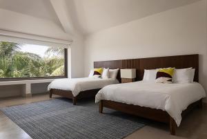 a bedroom with two beds and a large window at Luxury villa 5 bdr oceanfront 5 min walk to cenote in Puerto Aventuras +23 photos