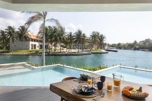 a table with food and a view of a pool at Luxury villa 5 bdr oceanfront 5 min walk to cenote in Puerto Aventuras