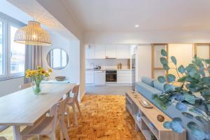 a living room with a table and a blue couch at BeGuest Retiro da Vila - 15min walk from the center - in Abuxarda