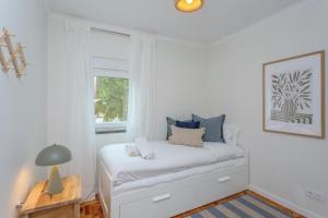 a white room with a bed with a window at BeGuest Retiro da Vila - 15min walk from the center - in Abuxarda