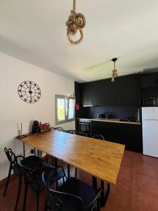 a kitchen with a wooden table and black cabinets at Assossego House - Gerês in Geres