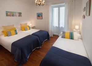 two beds in a room with white and blue at Earra - Eder, 3 min. playa y en pleno centro in Zarautz
