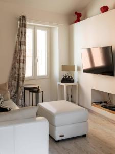 sala de estar blanca con sofá blanco y TV en Cocon dans la vieille ville, en Villefranche-sur-Mer