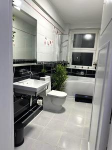 a bathroom with a sink and a toilet and a tub at Lush Jacuzzi Apartment 2 Bedrooms with Balcony & Parking in Birmingham