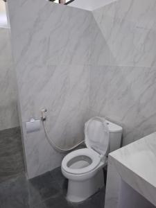 a bathroom with a toilet with a roll of toilet paper at Compass Homestay in Huu