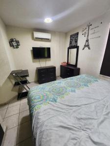 ein Schlafzimmer mit einem Bett und einem Flachbildfernseher in der Unterkunft Casa Comfortable and Complete, maximum 8 people in Tierra Colorada