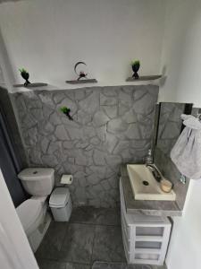 ein Badezimmer mit einem Waschbecken und einer Steinmauer in der Unterkunft Casa Comfortable and Complete, maximum 8 people in Tierra Colorada