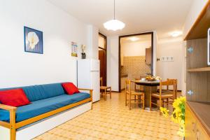 a living room with a blue couch and a table at Residence Acapulco in Porto Santa Margherita di Caorle
