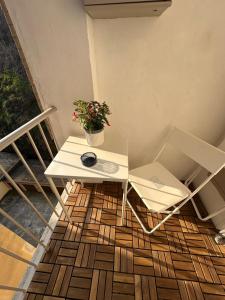 a white table and chair on a balcony with a plant at Casa di Otti in Ivrea