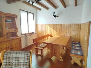 a dining room with a wooden table and a window at Villa Carla - Bosco in Ledro