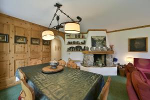 a dining room with a table and a fireplace at Chesa Spedlas - Celerina in Celerina