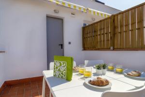 a table with plates of food and orange juice at Ola Living Camp Nou in Hospitalet de Llobregat