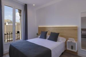 a bedroom with a large bed and a large window at Ola Living Camp Nou in Hospitalet de Llobregat